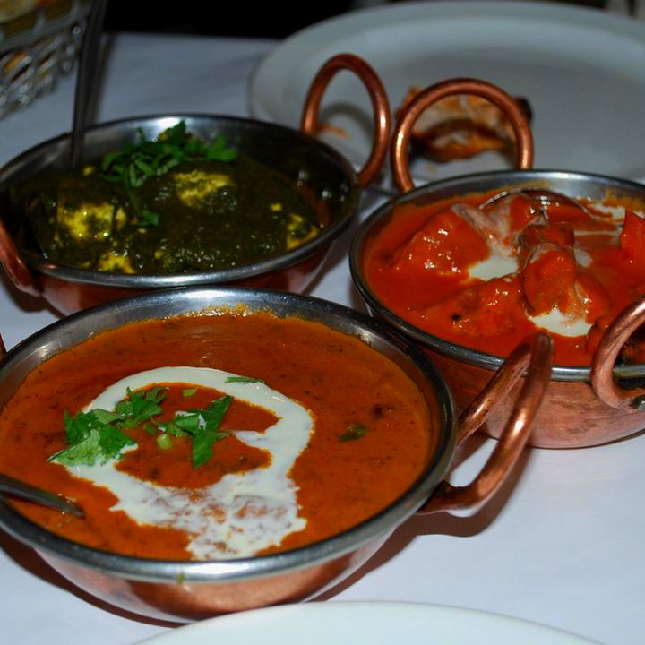 Palak paneer, dal and curry served in copper bowls